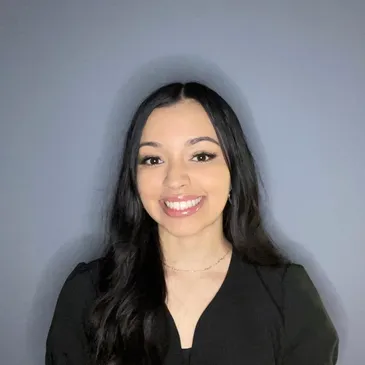 A woman in black shirt smiling for the camera.