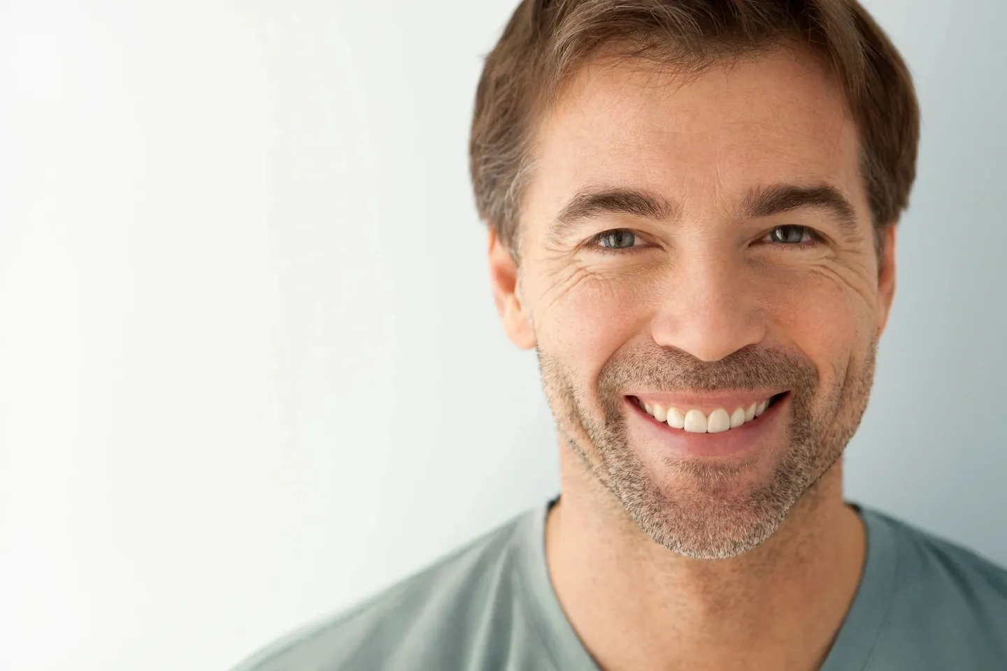 A man with white teeth smiling for the camera.