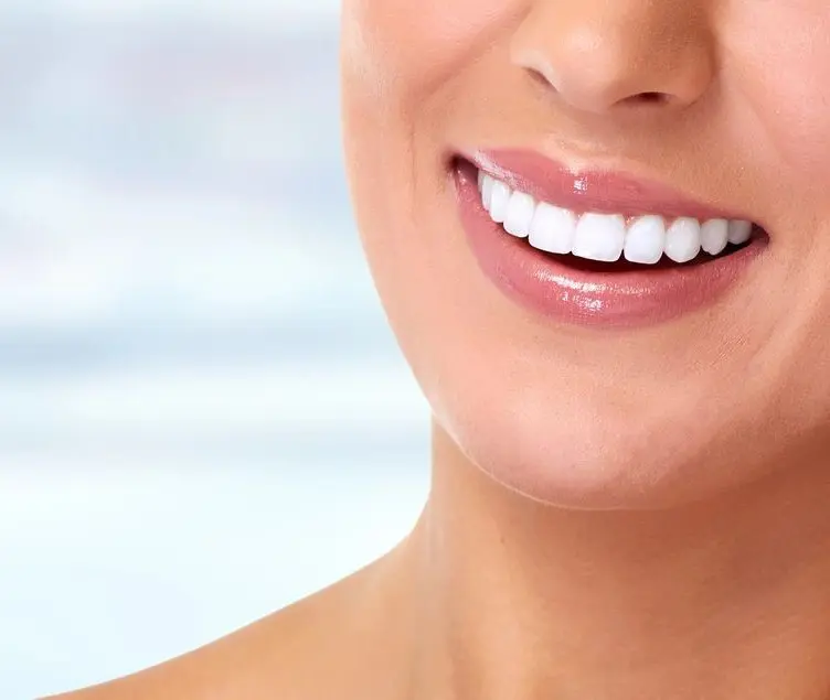 A woman with white teeth smiling for the camera.